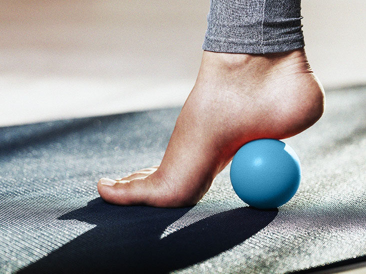 Myofascial release of hyper-movable muscles of the foot with a massage ball on a gymnastic mat at home. Prevention of leg fatigue after wearing high heel shoes